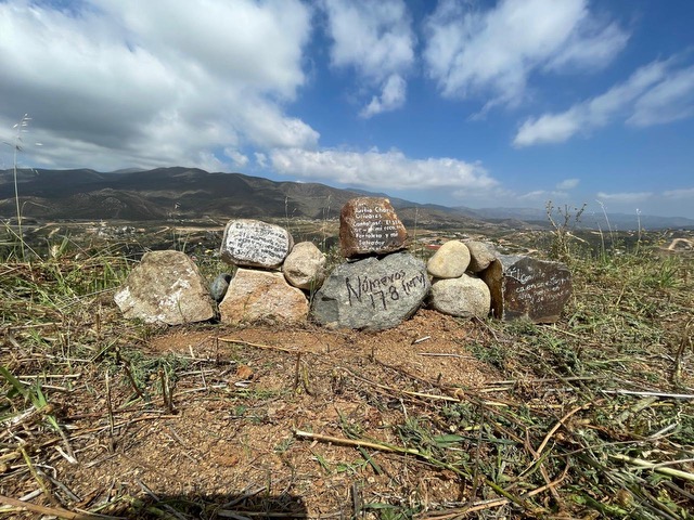 Altar de piedras con la promesa escrita — mirador hacia Ensenada