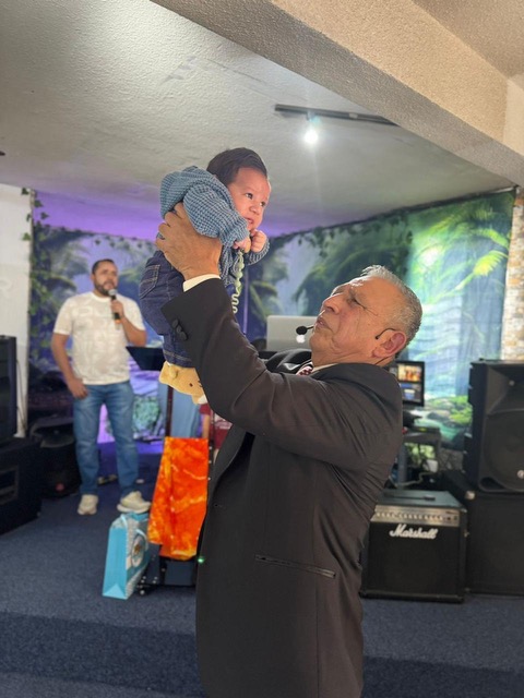 Pastor levantando al niño en dedicación